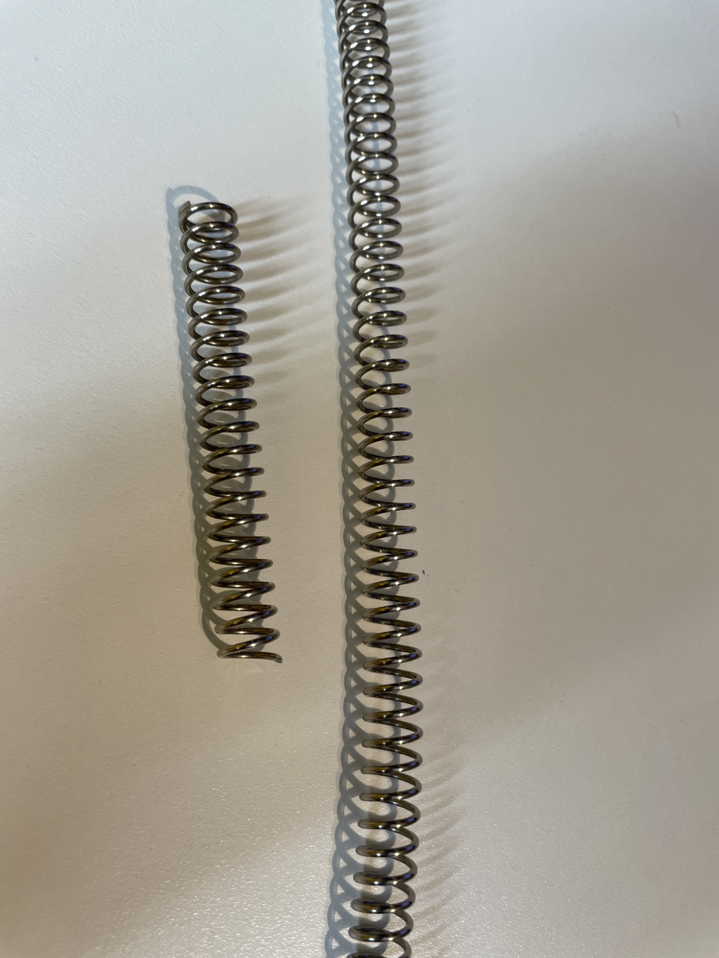 Photographie d'un ressort coupé et d'un long ressort